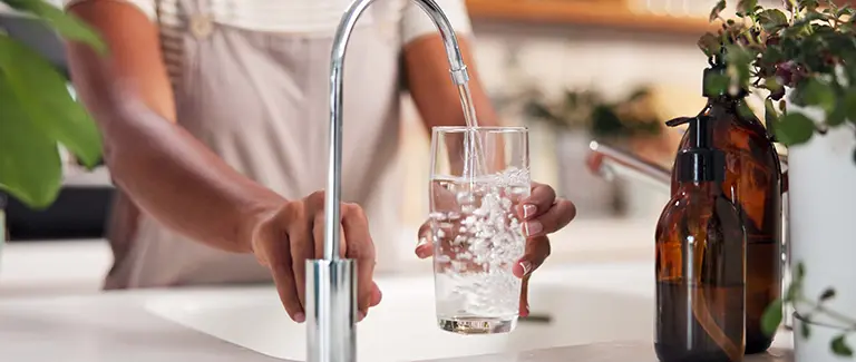 Woman getting clean water from sink